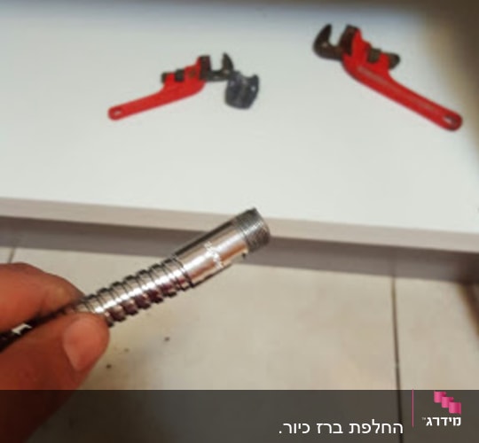 יד מחזיקה צינור מתכת, מפתח צינורות אדום ברקע
